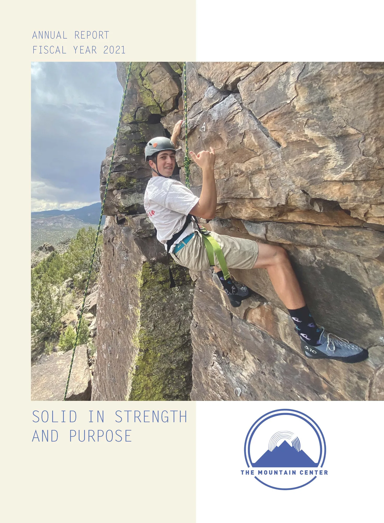 Cover of the FY2021 annual report, Solid in Strength and Purpose, with a young climber on a rock face
